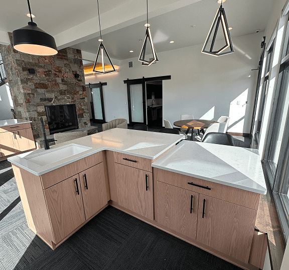 Modern kitchen corner with white countertops and wooden cabinets.